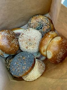 a box filled with assorted bagels sitting on top of a table