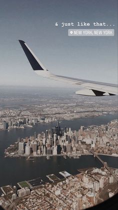 an airplane wing flying over a large city and lake in new york, usa with the words just like that above it