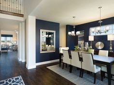 a dining room with blue walls and white chairs is pictured in this image from the inside