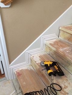 some tools are laying on the floor next to stairs