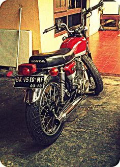 a red motorcycle parked in front of a building