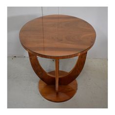 a round wooden table sitting on top of a white floor