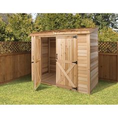 a wooden storage shed with doors open on the grass in front of a fence and trees