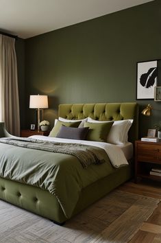 a bedroom with green walls and a bed in the middle, along with two lamps on either side of the bed