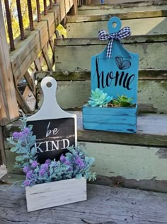 two wooden signs sitting on the steps with succulents