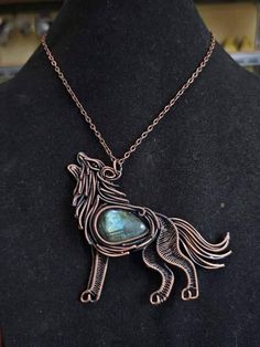 a necklace with a horse on it and a stone in the shape of a heart