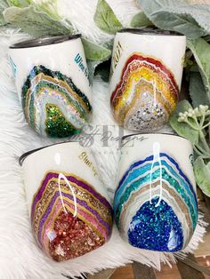 four hand painted coffee mugs sitting on top of a white furnishing area