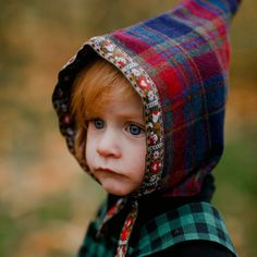 a young child wearing a hoodie and looking at the camera