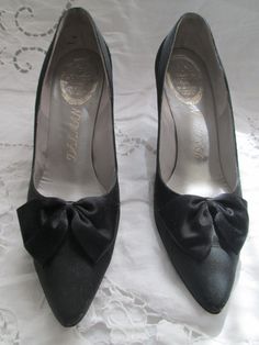 "Cute black 3\" heel pumps, in a sateen-like fabric with a large satin bow on front of shoe. Shoes are in a size 8 1/2 AA, in great condition. They also have a satin trim around top of shoe back/sides. PRICE IS $79.00SALE FINAL/AS IS/NO RETURNS." Classic Evening Heels With Bow, Round Toe Heels With Satin Bow For Evening, Evening Heels With Satin Bow And Round Toe, Formal Closed Toe Court Shoes With Bow, Formal High Heel Heels With Satin Lining, Formal High Heels With Satin Lining, Retro Pointed Toe Court Shoes For Party, High Heel Court Shoes With Bow For Evening, Vintage High Heel Court Shoes For Party