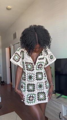 a woman with an afro standing in front of a tv