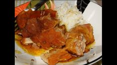 a white plate topped with meat and rice