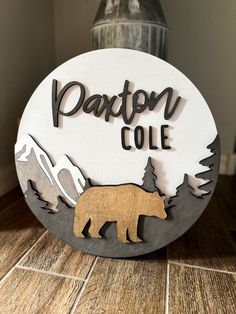 a wooden sign that says paxton cole with a bear on it