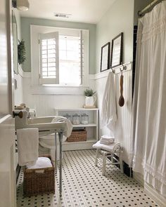 a white bathroom with black and white floor tiles