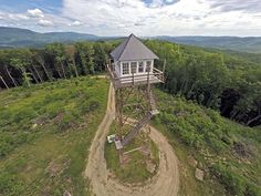 an aerial view of a small tower on top of a hill in the middle of nowhere