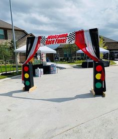 an entrance to a race track with red, white and green lights