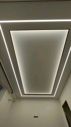 the ceiling in an office building is lit up with white lights and recessed lighting