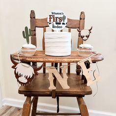 a wooden chair with cupcakes and decorations on it