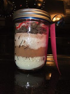 a mason jar filled with chocolate and marshmallows on top of a counter