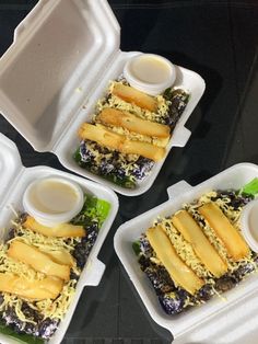 three takeout containers with food in them on a table top, one is filled with cheese and the other two are empty