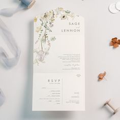 the wedding stationery is laid out with ribbons and flowers