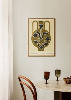 a table with two chairs and a painting on the wall