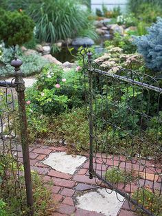 an iron gate in the middle of a garden