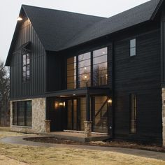 a large black house with lots of windows on the front and side of it's building