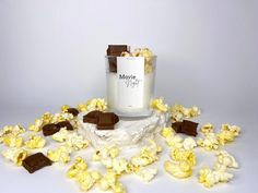 popcorn and chocolate pieces are scattered around a candle