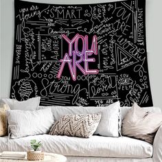 a black and pink wall hanging over a white couch