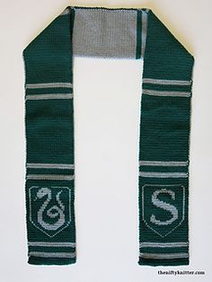 the scarf is green and gray with white letters on it, along with a snake