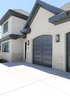 a white house with two garage doors and windows