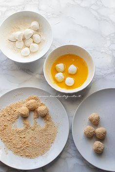 four plates with different types of food in them on a marble table top, including marshmallows and orange juice