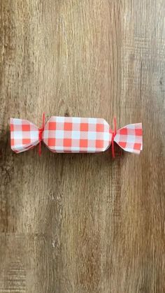 an orange and white checkered paper roll on top of a wooden table