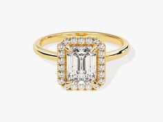 a yellow gold ring with an emerald cut diamond in the center, surrounded by small diamonds