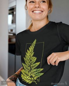 "This fern leaf t-shirt is great for plant, flower, and garden lovers. Great gift for anyone who spends their time enjoying nurseries, plant shopping, and botanical gardens. FABRIC CONTENT:  - Fabric content varies based on color. Solid colors are 100% cotton, heather colors are 52% cotton/48% polyester, Athletic Heather and Black Heather are 90% cotton/10% polyester) - Light fabric (4.2 oz/yd² (142 g/m   FIT & CONSTRUCTION :  - Runs true to size (sizing runs slightly larger for women, as this is a unisex style) - Side seams help hold the garment's shape longer and give structural support - Highly elastic ribbed knit collar and neck seam helps retain neck shape  - Reinforced shoulder and neck seams stabilize the back of garment and prevents stretching   SIZING : Please see sizing image as Botanical Graphic Print Green Tops, Botanical Green Tops With Plant Print, Green Botanical Graphic Print Tops, Green Botanical Short Sleeve Top, Green Botanical Print Tops, Green Botanical T-shirt With Graphic Print, Botanical Green T-shirt With Graphic Print, Botanical Style Green T-shirt With Graphic Print, Green Nature-inspired Crew Neck T-shirt