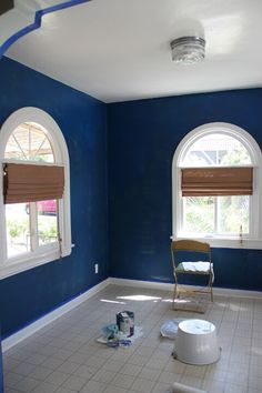 an empty room with blue walls and white tile flooring is being painted in the same color as the rest of the room