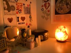 a table with some candles and pictures on the wall next to it in front of a mirror