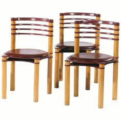 three wooden chairs with brown leather seats