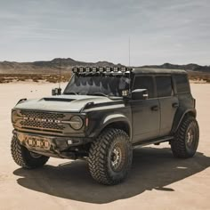 an off - road vehicle is parked in the desert