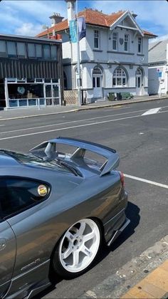 a grey sports car parked on the side of the road