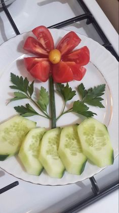 a plate with cucumber slices and a red flower on the top of it