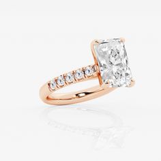 an engagement ring with a cushion cut diamond in the center and side stones on each band