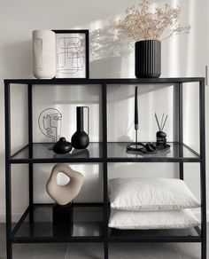 a shelf filled with vases and other items on top of a white tiled floor