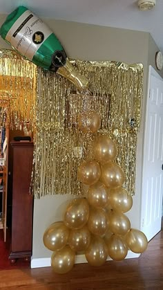 a bottle of champagne is being poured on top of balloons in the shape of a christmas tree