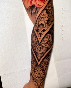 a woman's arm with flowers on it and an intricate design in the middle