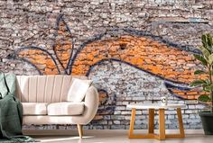 a living room with brick wall and white couches in front of an orange painted mural