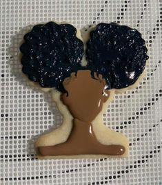 a cookie shaped like a woman's head with blue icing on top of it