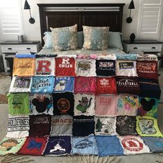 a bed covered in lots of t - shirts on it's sides and pillows