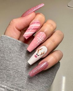 A playful yet chic pink manicure with glittery accents and charming Christmas details. Candy cane stripes, delicate snowflakes, and an adorable reindeer with festive antlers create a whimsical holiday vibe. The sparkly pink coffin-shaped nails offer a modern twist on traditional Christmas colors, making this design perfect for a fun and festive look.#ChristmasNails #HolidayManicure #FestiveFingers #MerryManicure #NailArtInspiration #WinterNails #HolidayNailDesigns #ChristmasNailIdeas #NailGoals December Nails Reindeer, Christmas Nails On Brown Skin, Winter Christmas Nails Coffin, Almond Shape Christmas Nail Designs, Christmas Nails Acrylic Reindeer, Acrylic Nails For Christmas Holiday, Reindeer Nails Acrylic, December Coffin Nails, Girly Holiday Nails