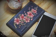 a cell phone sitting on top of a wooden table next to a flowered wallet